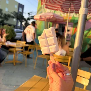 a person holding a piece of ice cream