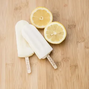 two lemons and a popsy on a wooden table