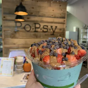 a hand holding a bowl of food