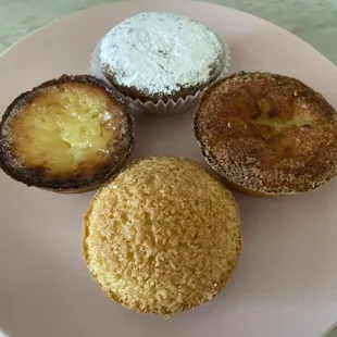 Clockwise from top: Cinnamon tart with powdered sugar on top, orange flavored custard tart, coconut tart, custard tart