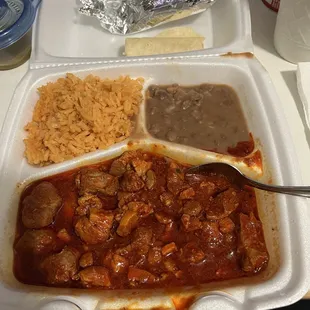 Puerco guisado (pork stew), rice, beans, green hot sauce and five tortillas.