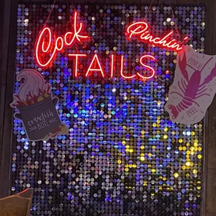 a neon sign for cocktail tails