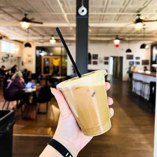 a hand holding a cup of iced coffee