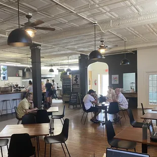 people sitting at tables in a cafe