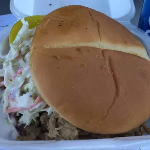 a pulled pork sandwich with coleslaw and coleslaw slaw