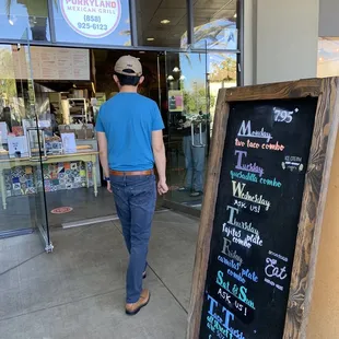  a man walking in front of the restaurant