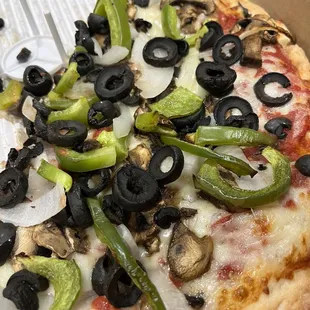 a pizza with black olives and green peppers