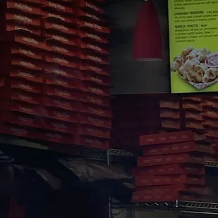 a large stack of pizzas