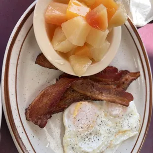 (2) over-easy eggs, bacon, and fruit cup