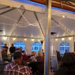 a group of people sitting under a tent