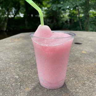 a pink drink with a green straw