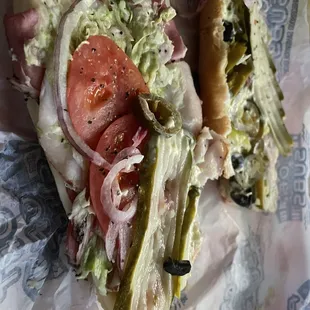 half of a large turkey, pastrami sandwich so thin on the meats and cheese.