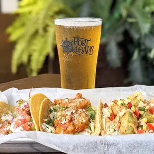 a tray of tacos and a pint of beer