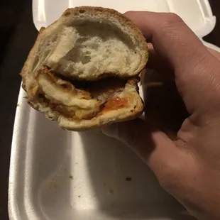 a hand holding a sandwich