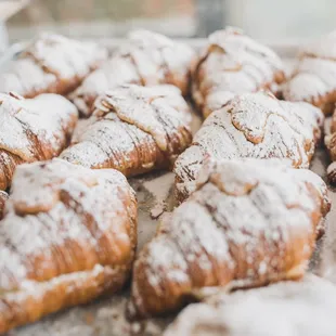 a tray of pastries with powdered sugar on them