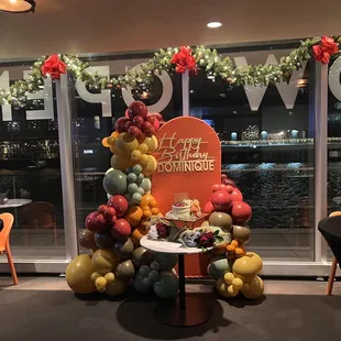 a table with a cake and balloons