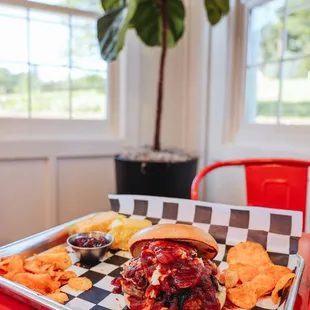 a bbq sandwich and chips on a tray