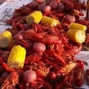 crawfish, corn, potatoes, and corn on a newspaper