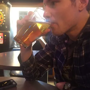 a man drinking a pint of beer