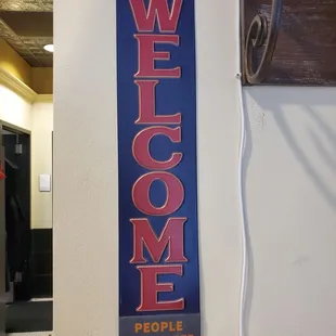 a welcome sign hanging on a wall