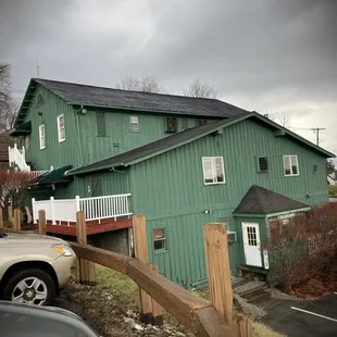 a green building with a wooden fence
