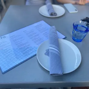 a plate with a napkin and a glass of water
