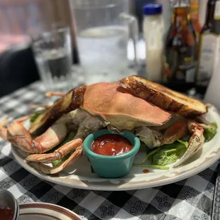 a plate of crab legs and a bowl of ketchup