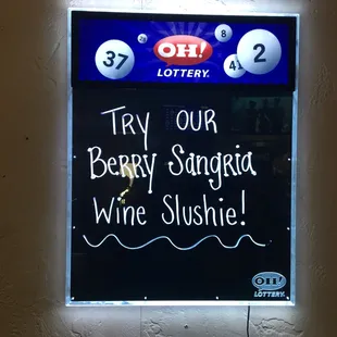 a blackboard with a sign that says try our berry sangri wine slushe