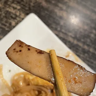 a piece of sushi on a chopstick