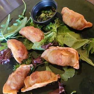 Gyozas over wilted Greens