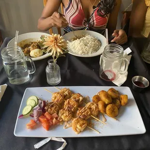 a woman sitting at a table with a plate of food