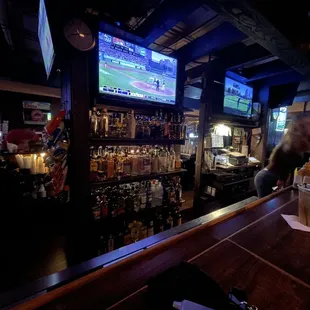 a man at a bar watching television
