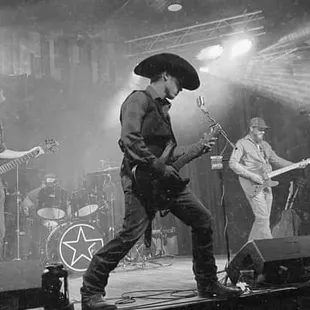a black and white photo of a band performing on stage