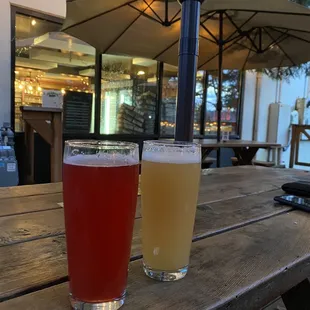 two glasses of beer on a picnic table