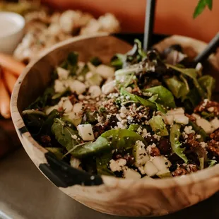 a wooden bowl of salad with carrots