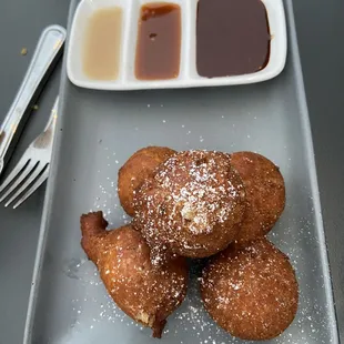 Hot Donut Dots with three dipping sauces: salted butter chocolate, caramel and vanilla glaze.