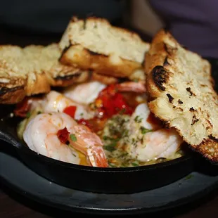 The Shrimp Scampi is made with butter poached jumbo shrimp, artichoke, calabrian chili, chablis spritz, &amp; focaccia.