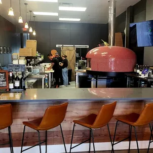 a bar with a pizza oven in the background
