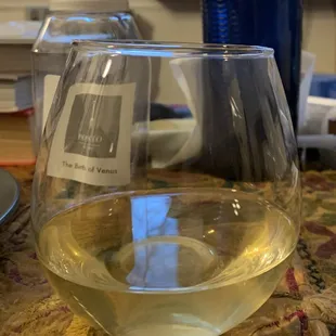 a glass of white wine on a table