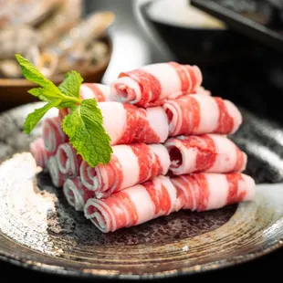 pile of hot pot rolls on a plate with a sprig of mint