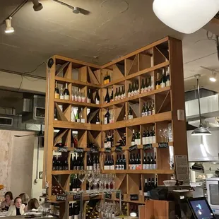 a view of a kitchen with a lot of bottles on the shelves