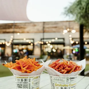 two takeout containers of fries on a table