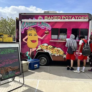 a group of people standing in front of a food truck