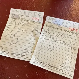 two receipt papers on a table