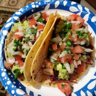 two tacos on a paper plate