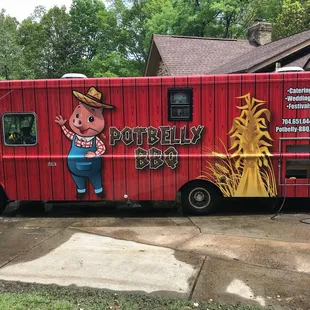 a red food truck parked in front of a house