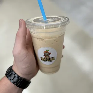 a hand holding a cup of iced coffee
