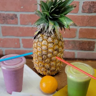 a pineapple, orange, and smoothie