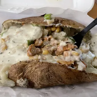 Baked potato with grilled chicken, green onions, corn, and garlic sauce
