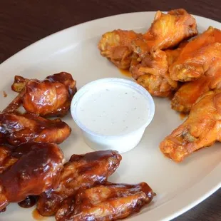 a plate of chicken wings and dipping sauce